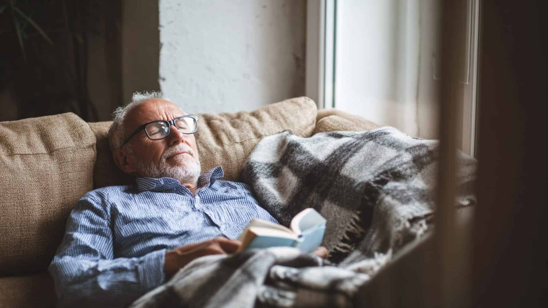 an old man sleeping on sofa