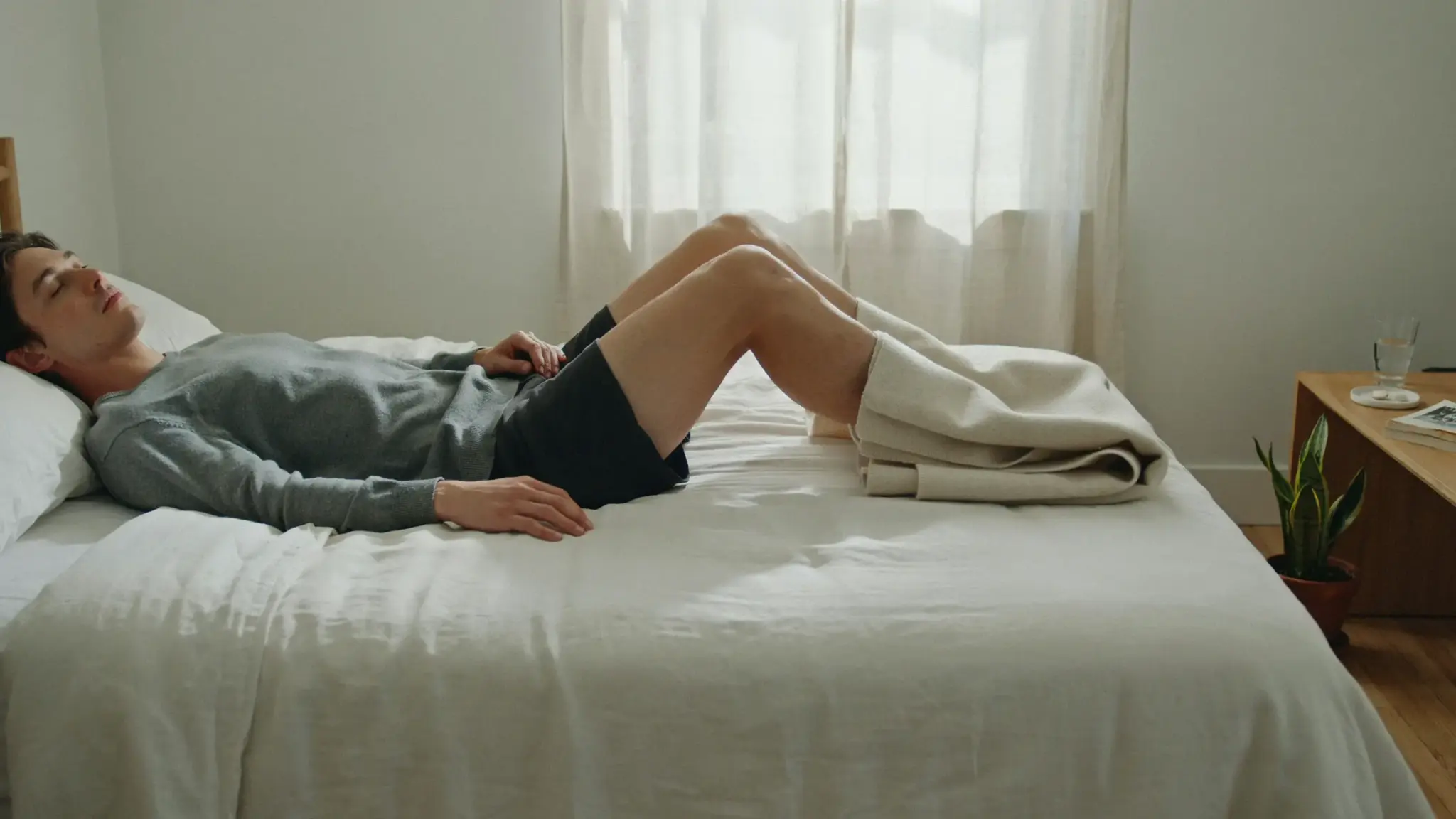 Person lying on back with legs elevated on pillows to reduce knee swelling and IT band discomfort.