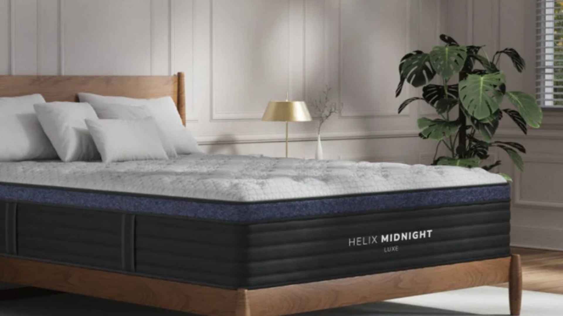 Helix Midnight Luxe hybrid mattress in elegant bedroom with wood frame, pillows, and indoor plants.