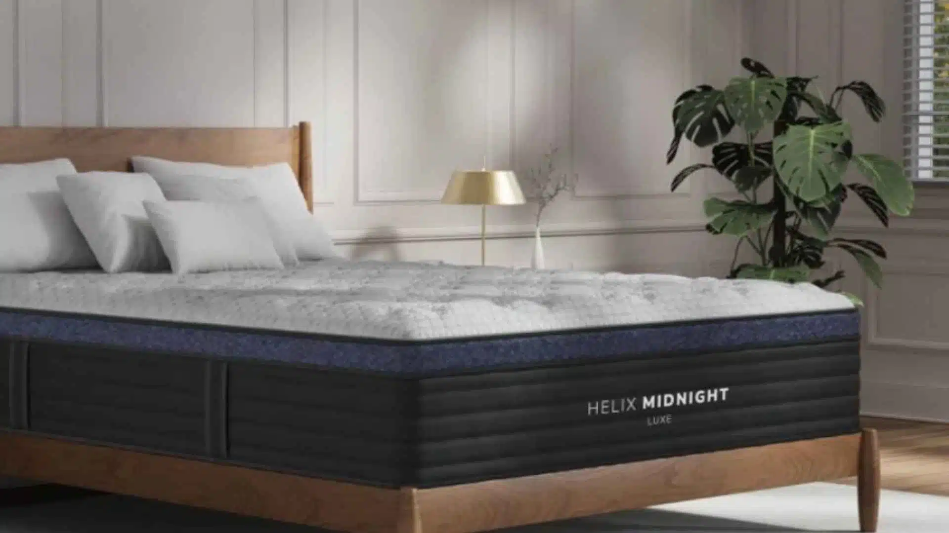 Helix Midnight Luxe hybrid mattress in elegant bedroom with wood frame, pillows, and indoor plants.
