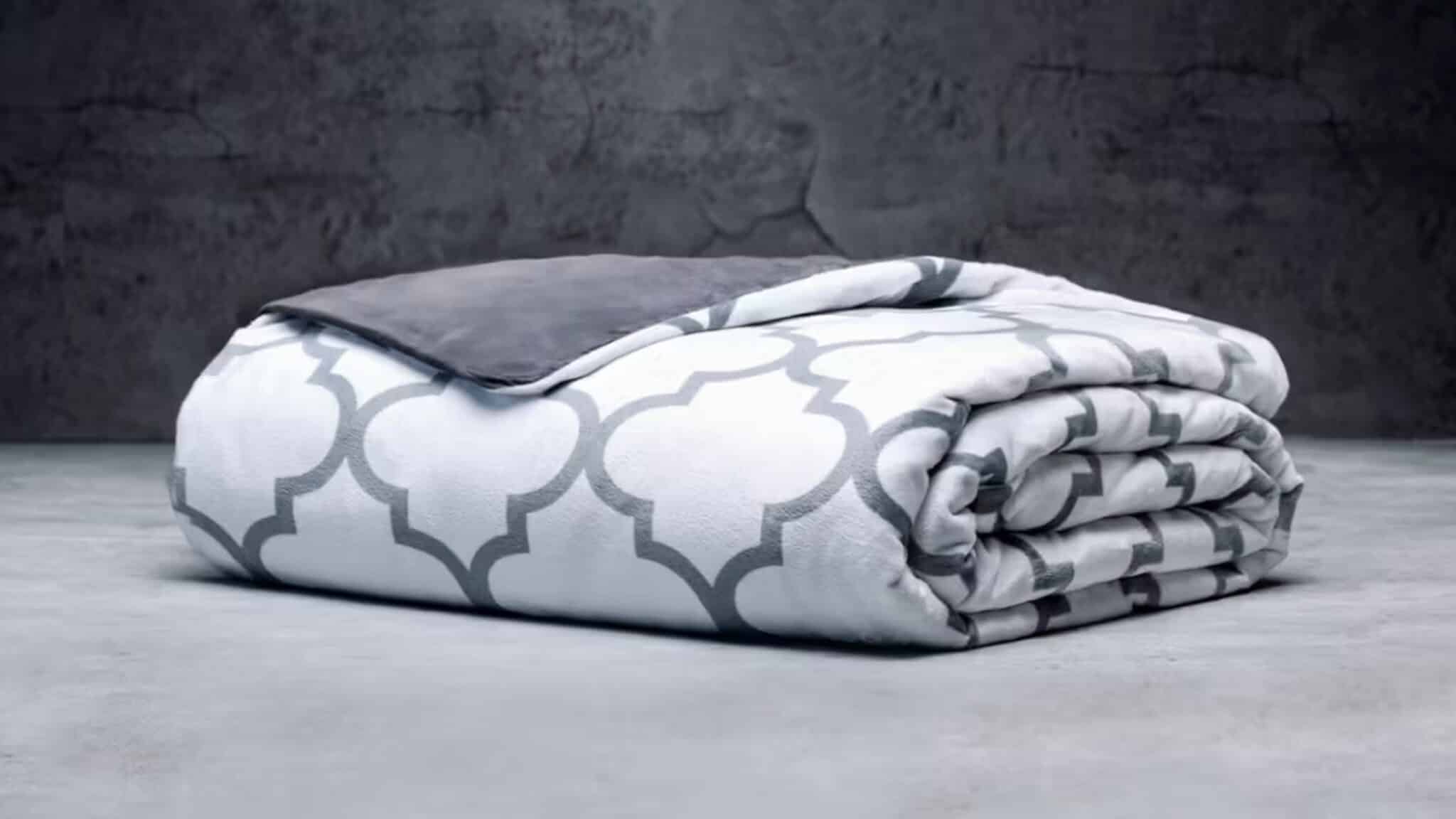 Folded white and gray patterned weighted blanket on a surface