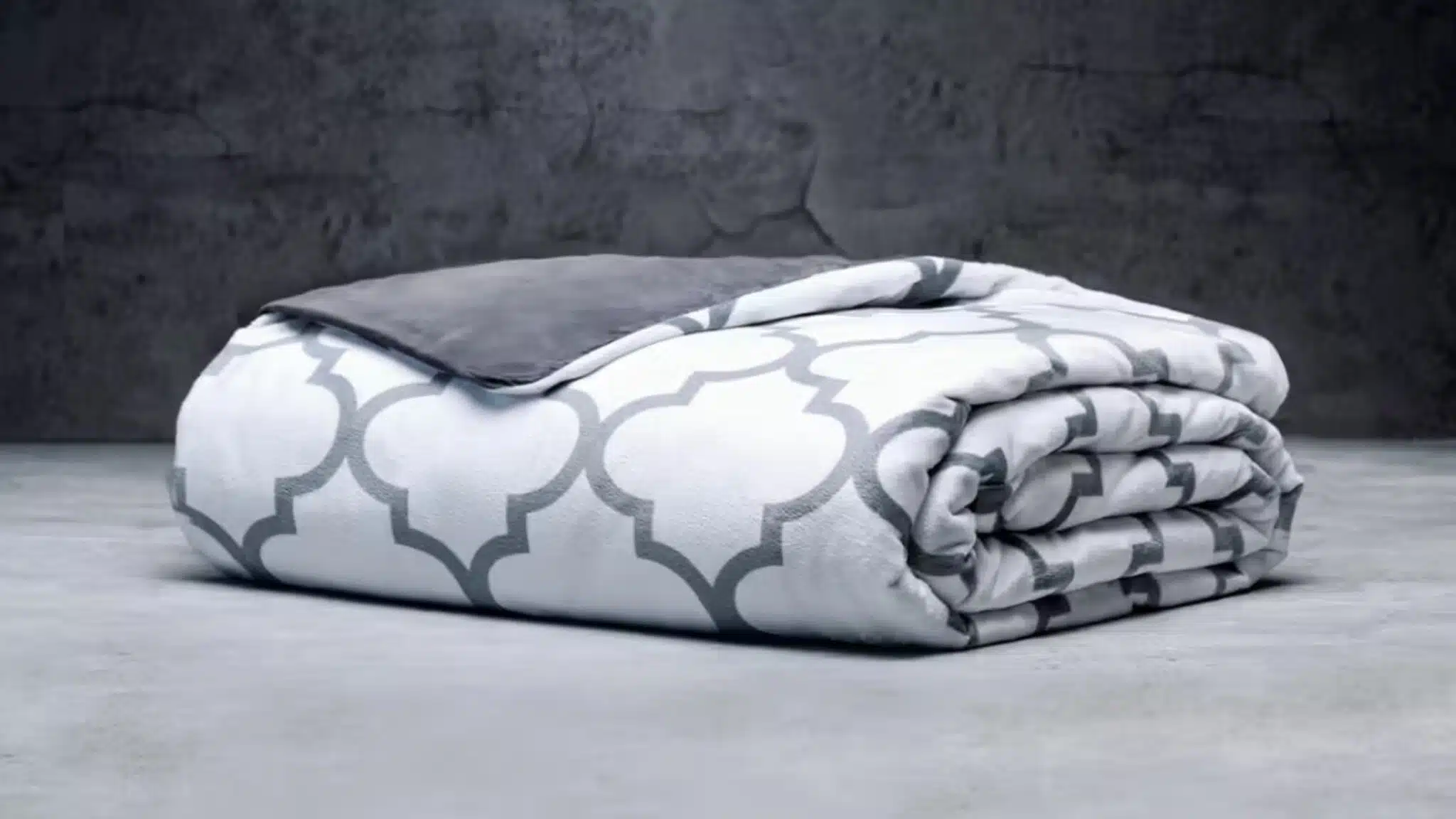 Folded white and gray patterned weighted blanket on a surface