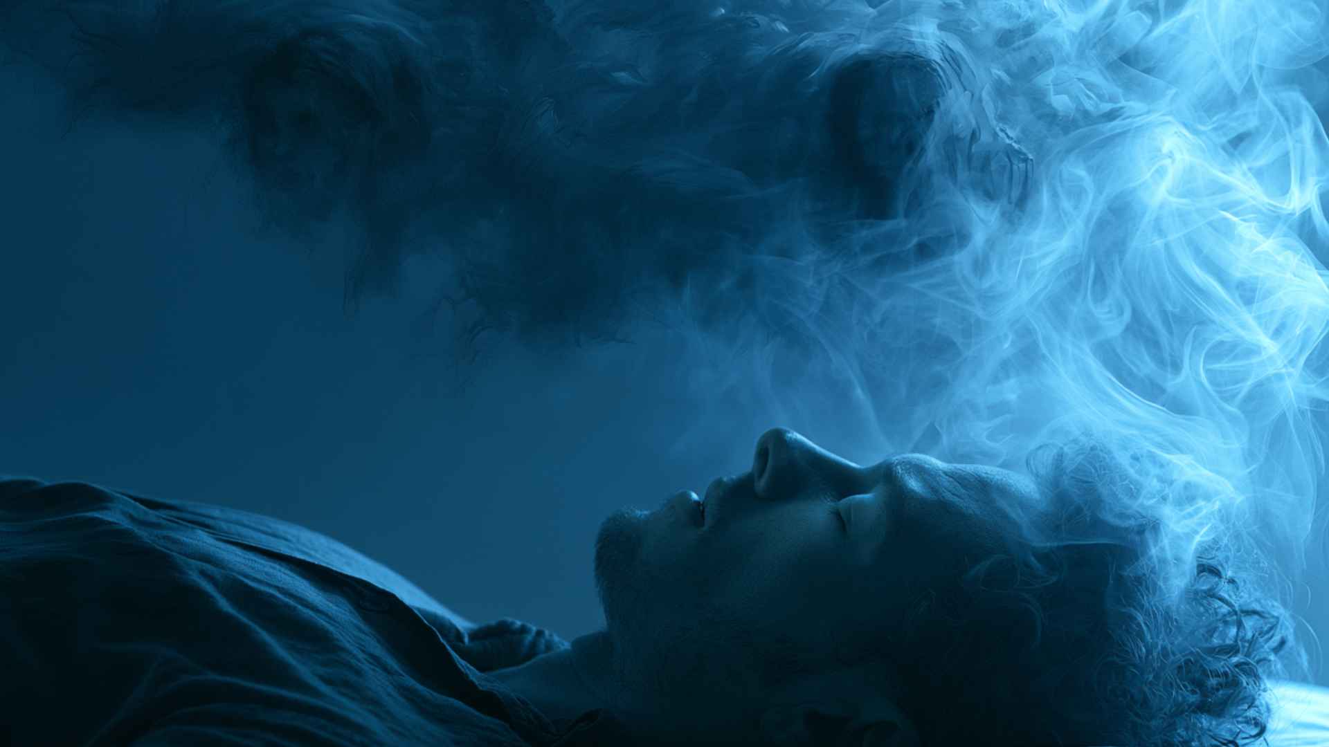 Sleeping adult with a distressed expression during REM sleep, soft blue moonlight filtering through bedroom curtains
