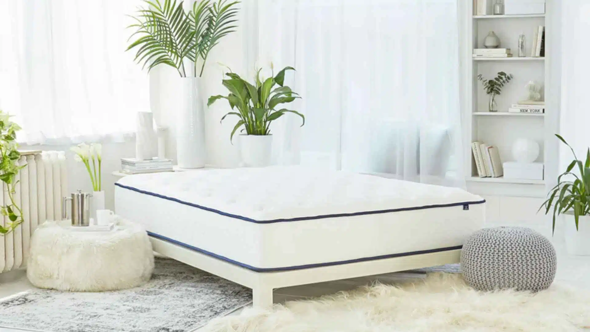Puffy Lux memory foam mattress in bright white bedroom with cozy decor, plants, and soft natural lighting.
