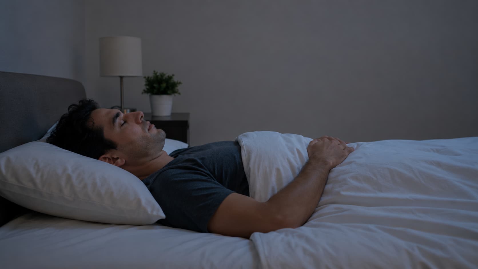 Man lying on back in bed with pillow, resting peacefully in bedroom, supporting neck alignment for herniated C6-C7 condition sleeping.