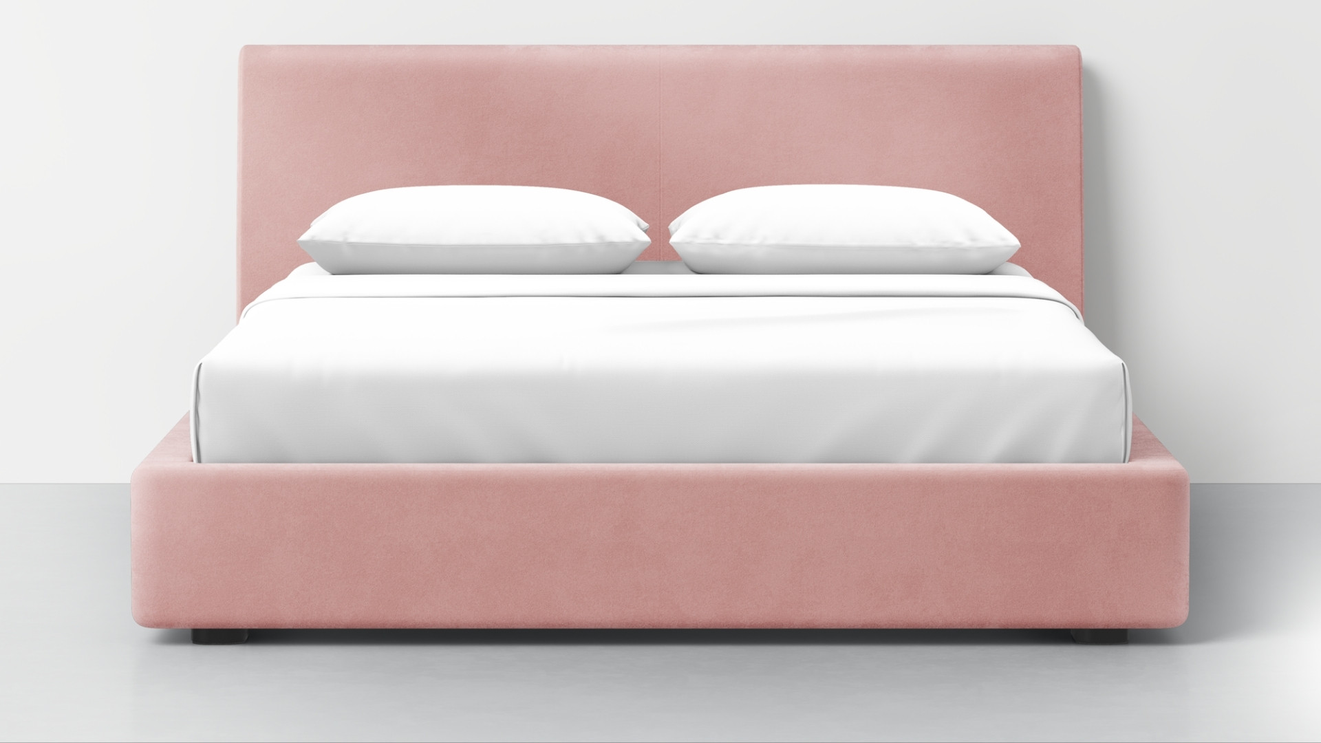 Pink Buchanan Studio Signature bed frame with a tall headboard, crisp white bedding, and two pillows against a simple light gray wall