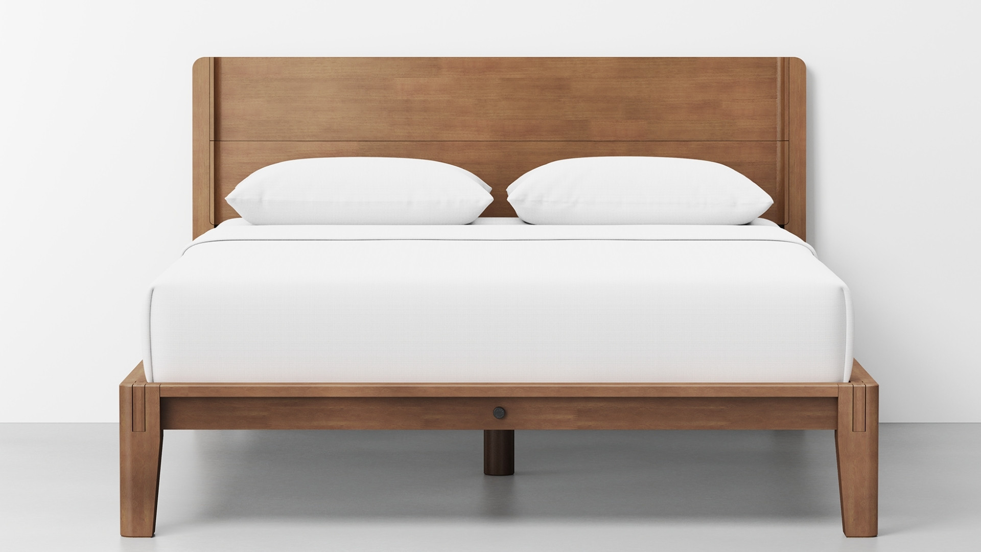 Thuma Classic Bed featuring a low-profile wooden platform frame in a warm walnut finish with a matching solid headboard